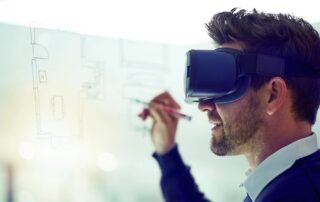 Mann mit Virtual-Reality-Brille zeichnet einen Grundriss auf eine Glaswand